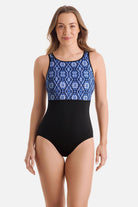 Woman wearing a blue tile printed one-piece swimsuit