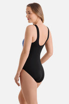 Woman turned left wearing a blue tile printed one-piece swimsuit