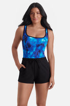 Woman wearing a black and blue water print swim romper