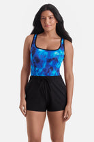 Woman wearing a black and blue water print swim romper