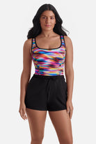 Woman wearing a rainbow tie dye one-piece swim romper