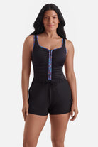 Woman wearing a one-piece romper swimsuit with rainbow piping