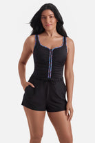 Woman wearing a one-piece romper swimsuit with rainbow piping
