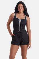 Woman wearing a black and white one-piece swim romper