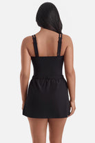 Woman turned away wearing a blue tile print one-piece swim dress