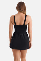 Woman turned away wearing a black swim dress