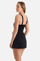 Woman turned left wearing a black and white abstract printed swim dress