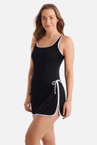 Woman turned left wearing a black swim dress with white piping/edges