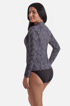 Woman turned left wearing a black and white maze pattern sunshirt