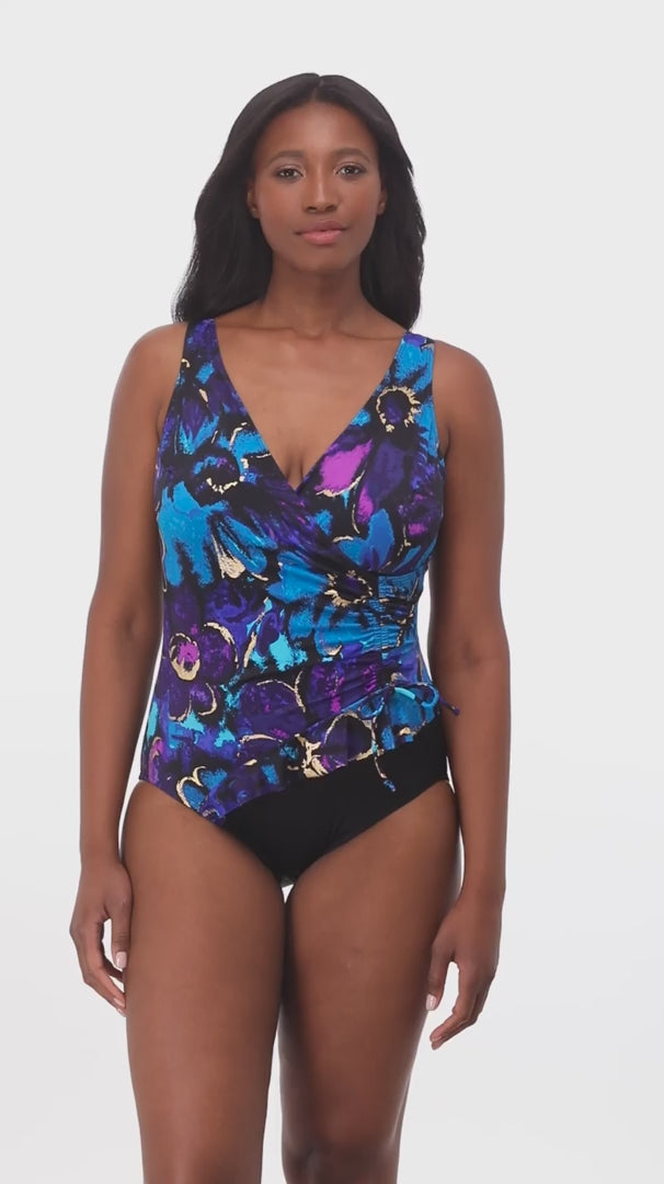 Woman wearing a blue and gold floral printed one-piece swimsuit