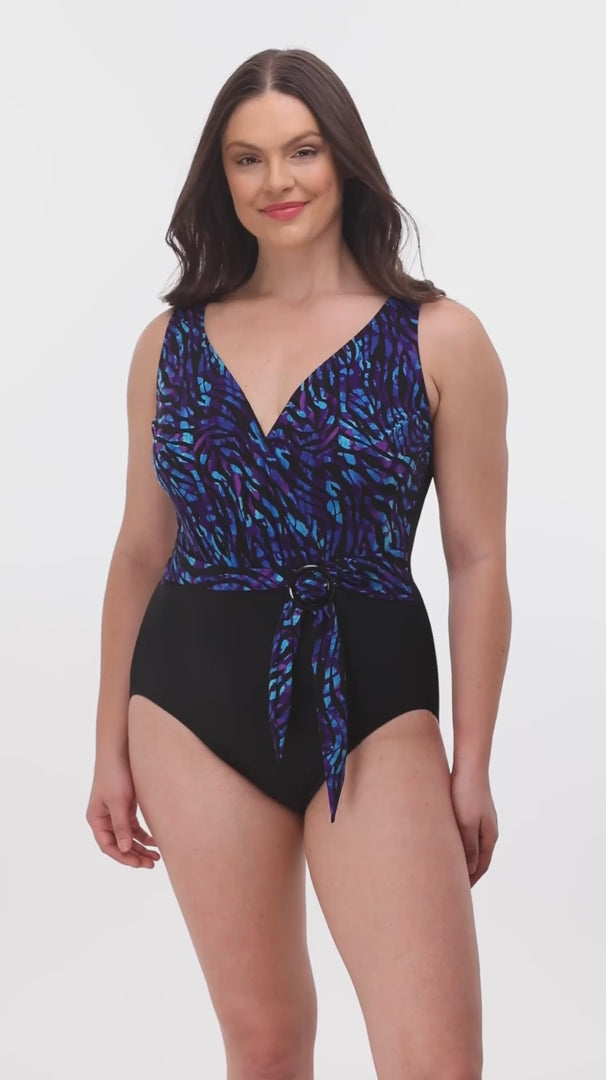 Woman wearing a black and blue safari printed one-piece swimsuit