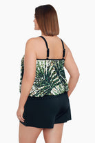 Woman turned left wearing a green and white palm leaf blouson tankini top