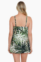 Woman faced away wearing a green and white palm leaf and brown dotted pattern swim dress