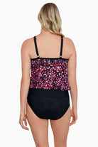 Woman faced away wearing a pink dotted pattern high neck blouson tankini top with mesh details