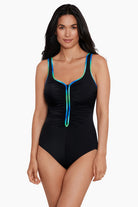 Woman wearing a black one-piece swimsuit with blue and green piping on the straps and down the front