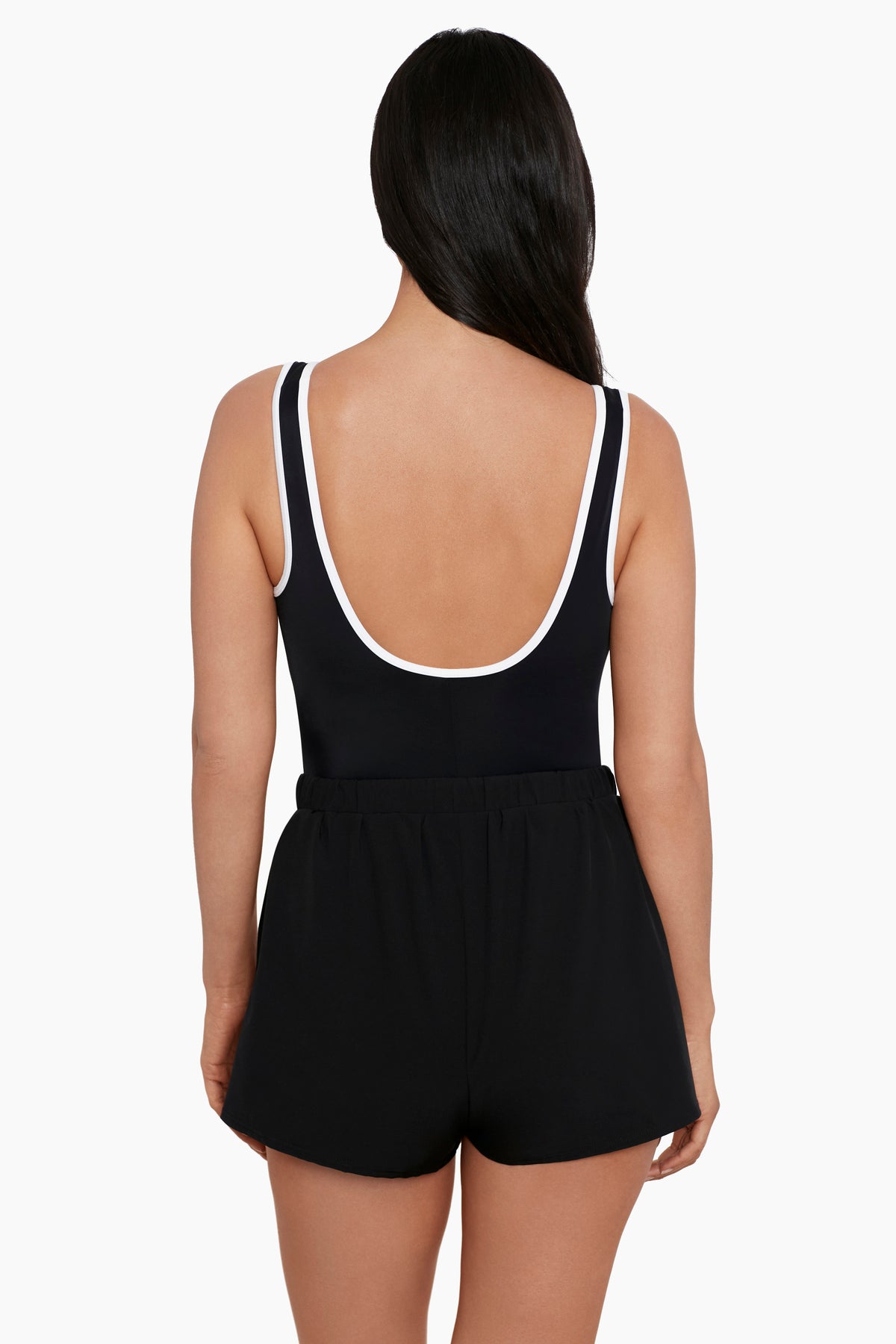 Woman faced away wearing a black swim romper with white piping on the edges